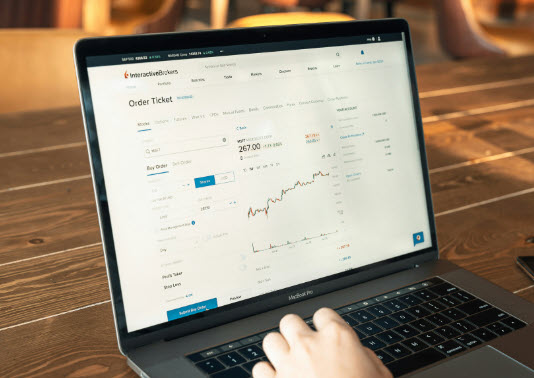 Person trading stocks on laptop